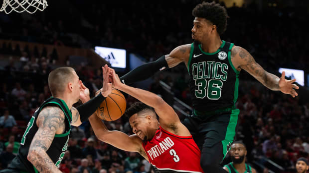 Feb 25, 2020; Portland, Oregon, USA; Portland Trail Blazers guard CJ McCollum (3) is fouled during the second half by Boston Celtics guard Marcus Smart (36) at Moda Center.